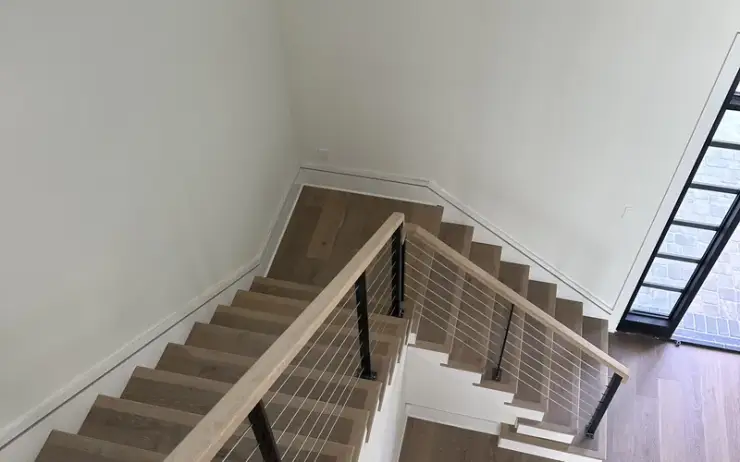 Modern stair treads with cable railing installation by Triangle Flooring